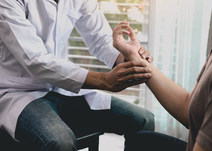 Persona visita al médico porque tiene dolor en la muñeca causado por tendinitis. Persona visita al médico porque tiene dolor en la muñeca causado por tendinitis.